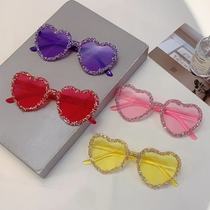 Macro shot of candy-colored heart-shaped rimless sunglasses with sparkling rhinestones
