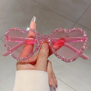 Close-up of pink heart-shaped rimless sunglasses featuring sparkling crystals on frames