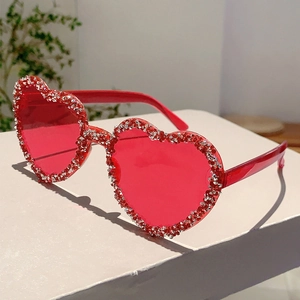 Detail of red heart-shaped rimless sunglasses with sparkling silver rhinestones on display