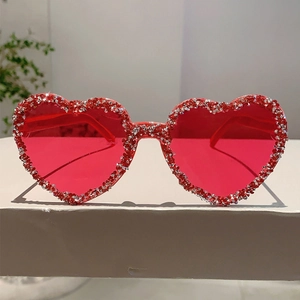 Detail of red heart-shaped rimless sunglasses with sparkling crystal-encrusted edges