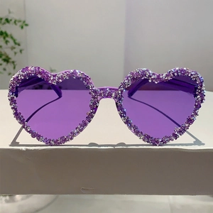 Close-up of purple heart-shaped rimless sunglasses with sparkling crystal rhinestones