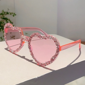 Detail of pink heart-shaped rimless sunglasses with sparkling rhinestones on the lenses