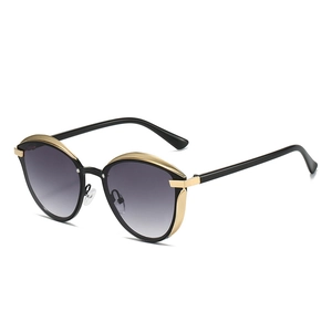 Lunettes de soleil œil-de-chat vintage avec verres dégradés et monture noire dorée
