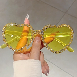 Fashionable heart-shaped yellow sunglasses with crystal rhinestones on the lenses