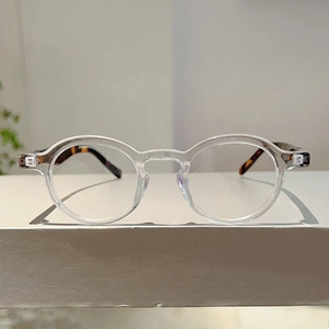Detail of round transparent frame glasses with vintage tortoiseshell patterned temples