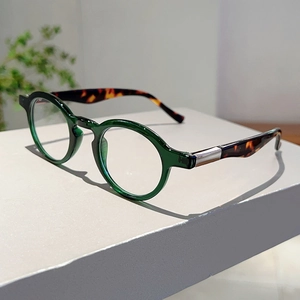 Detail view of retro round green frames and tortoiseshell temples with metal hinges