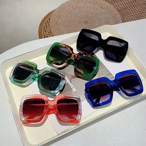 Five pairs of trendy oversized square sunglasses in assorted colors on a cream tray