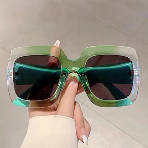 Modern square oversized sunglasses with transparent green frames and dark tinted lenses