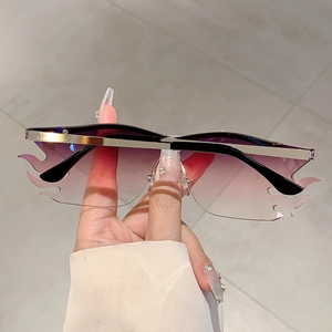 Macro detail of flame shaped frameless sunglasses with purple gradient lenses and gold bridge