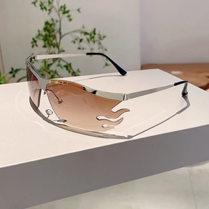 Detail of silver flame-shaped sunglasses with brown gradient lenses and rimless edges