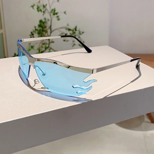 Detail of blue flame-shaped rimless sunglasses with silver metal temples on white pedestal