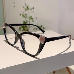Close-up of cat-eye glasses frame with silver rectangle accents on polished black material
