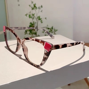 Detail view of cat eye glasses frames with tortoiseshell pattern and pink accents