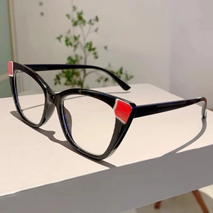 Detailed view of cat-eye glasses with unique red and white color blocking on black frames