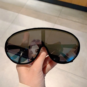 Detail view of bold Y2K oversized shield sunglasses with a sleek black wrap-around frame