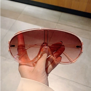 Close-up of Y2K wraparound pink sunglasses with gradient lenses and oversized frame