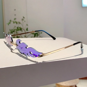 Close-up of purple flame-shaped lenses and golden metal frame of these fashion sunglasses