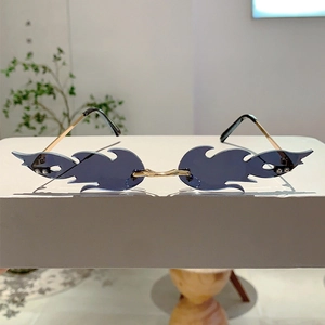 Close-up of rimless flame-shaped sunglasses with light blue lenses and gold metal temples