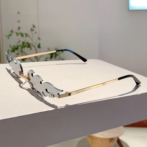 Detail of grey flame-shaped rimless lenses with elegant gold metal temples and hinges