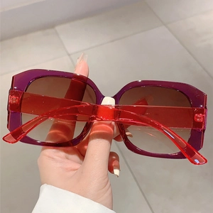Detail of square sunglasses with purple and red frame and brown gradient lenses