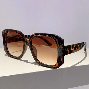 Detail shot of leopard print square frame sunglasses with gradient brown lenses on white stand