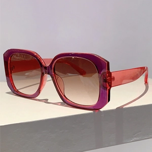 Macro detail of oversized square sunglasses with red to purple gradient translucent frame
