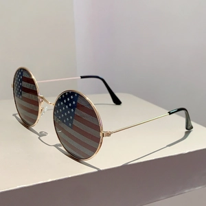 Detail of vintage round sunglasses featuring a golden frame and US flag lens design