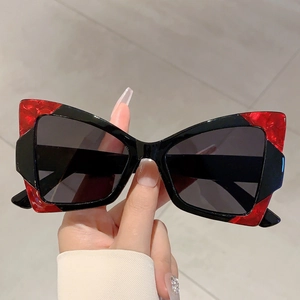 Detail of butterfly cat-eye sunglasses featuring red marble and black acetate frame