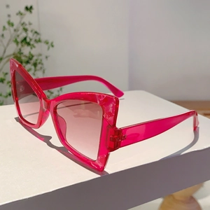 Detail of translucent rose pink cat-eye sunglasses with gradient lenses and thick temples
