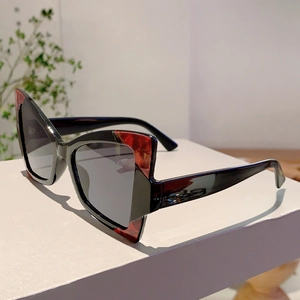 Detail of cat eye sunglasses with black frame and red marble patterned corner accents
