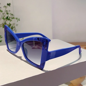 Side view of bright blue cat-eye sunglasses with thick frames and gradient grey lenses