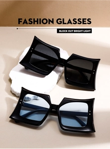 Macro detail of oversized butterfly sunglasses with silver studs and sleek black frames