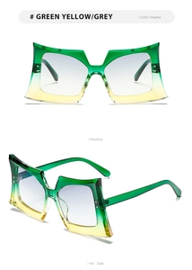 Close-up of butterfly sunglasses showing green-yellow gradient lenses and oversized frame