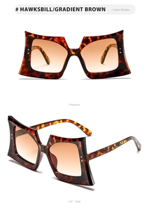 Detail view of tortoiseshell butterfly frame sunglasses with gradient brown lenses