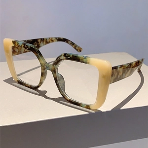 Detail shot of square two-tone glasses frame in ivory and tortoise pattern on pedestal