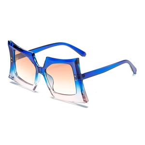 Oversized geometric butterfly sunglasses with blue to peach gradient lenses in a clear frame