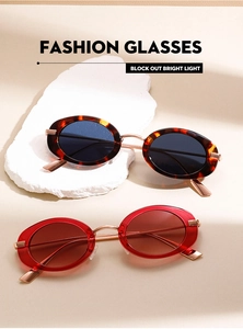 Detailed macro view of vintage oval sunglasses with tortoiseshell and transparent red frames
