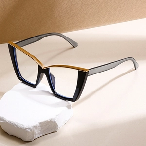 Blaulichtfilter Brille im Cat-Eye-Design mit schwarz-goldener Fassung auf Stein