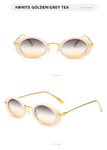 Detail view of oval beige sunglasses with golden metal temples and gradient lenses