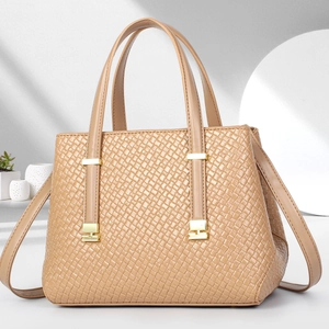 Detailed view of beige woven texture handbag with gold hardware and side pleat design