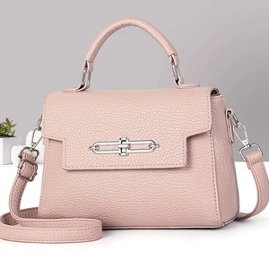 Detail of pink lychee leather handbag with silver chain lock and removable strap