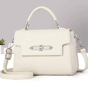 Detail of off-white lychee texture leather bag with silver chain twist lock and strap