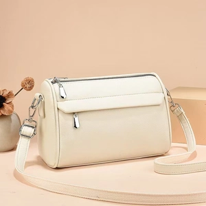 Detail of lychee textured leather crossbody bag with dual zippers and front flap pocket