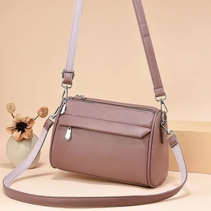 Dusty pink cylindrical crossbody bag with lychee texture and dual shoulder straps