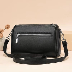 Detail of black lychee texture crossbody bag featuring silver hardware and front zipper