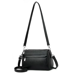 Detail of black lychee grain leather texture and polished silver metal hardware on the bag