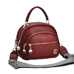 Deep red pebbled leather mini crossbody bag with wide strap and gold K hardware