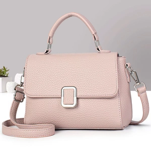 Detailed close-up of pink lychee grain leather crossbody bag with silver buckle