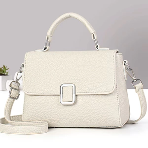 Close-up of beige lychee texture leather bag with elegant silver metallic buckle detail