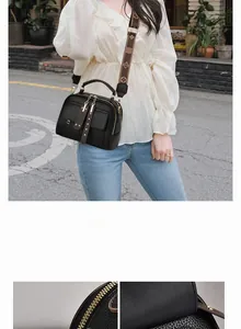 Detail of black pebbled leather crossbody bag with dual zippers and gold hardware